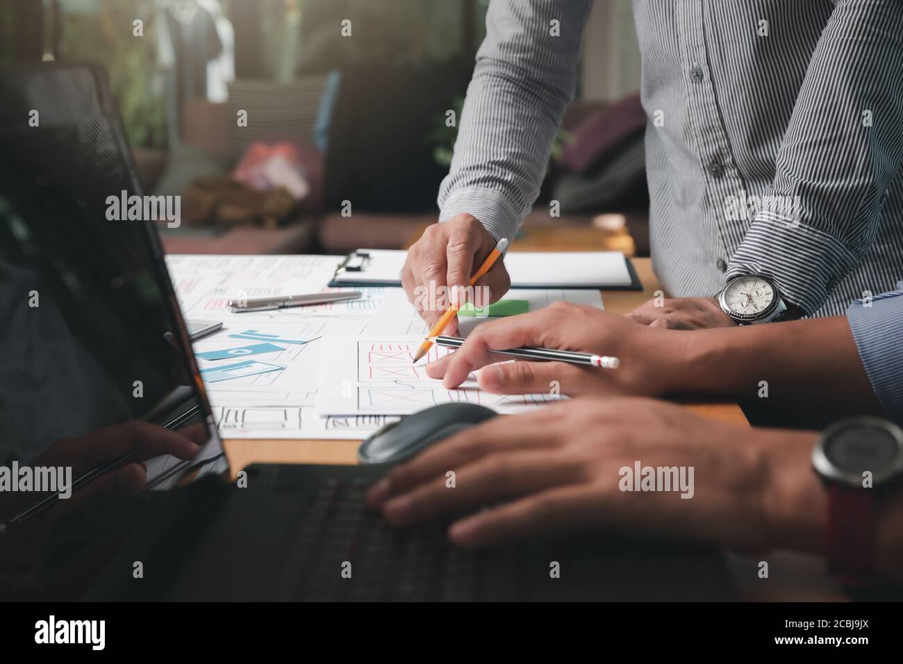 Diseñadores de UX o UI que diseñan en su proyecto prototipo de diseño de aplicaciones para smartphones. Foto de stock