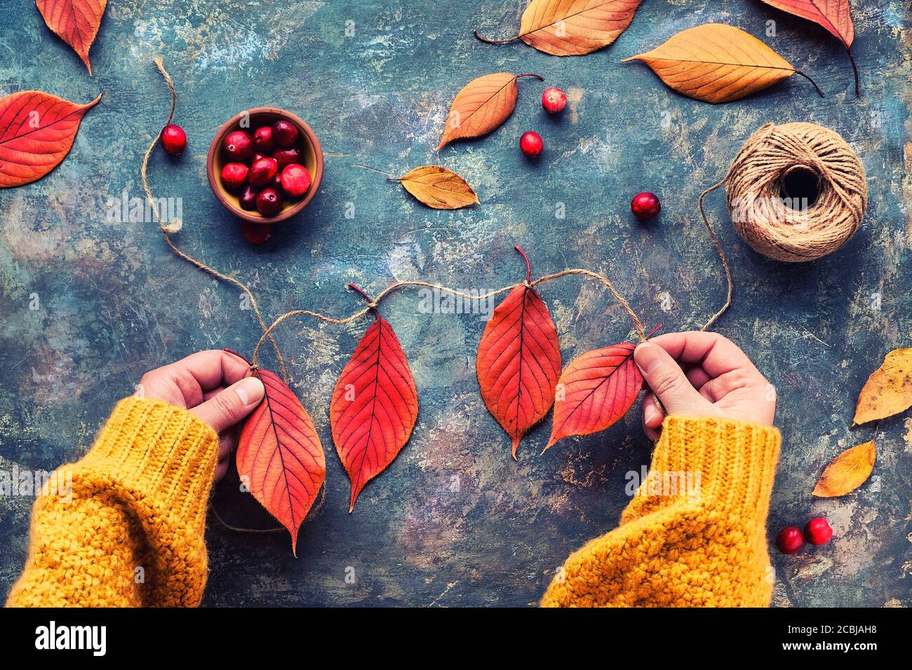 Decoración de otoño de bricolaje de materiales naturales. Hacer guirnalda  con cordón y hojas de otoño Fotografía de stock - Alamy