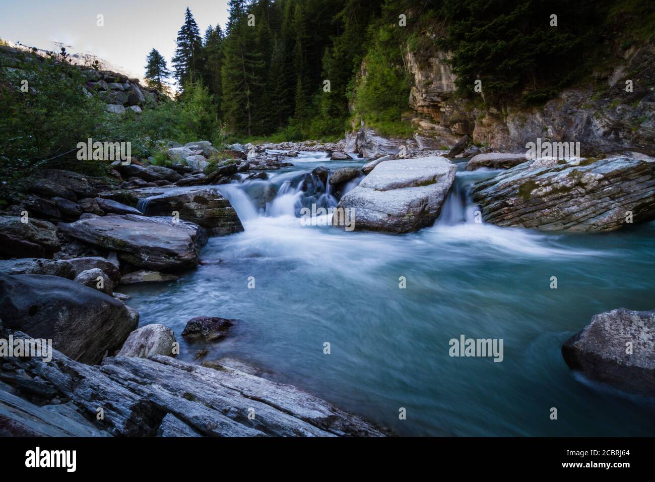 Pequeña cascada que corre a través de las rocas en los Alpes Foto de stock