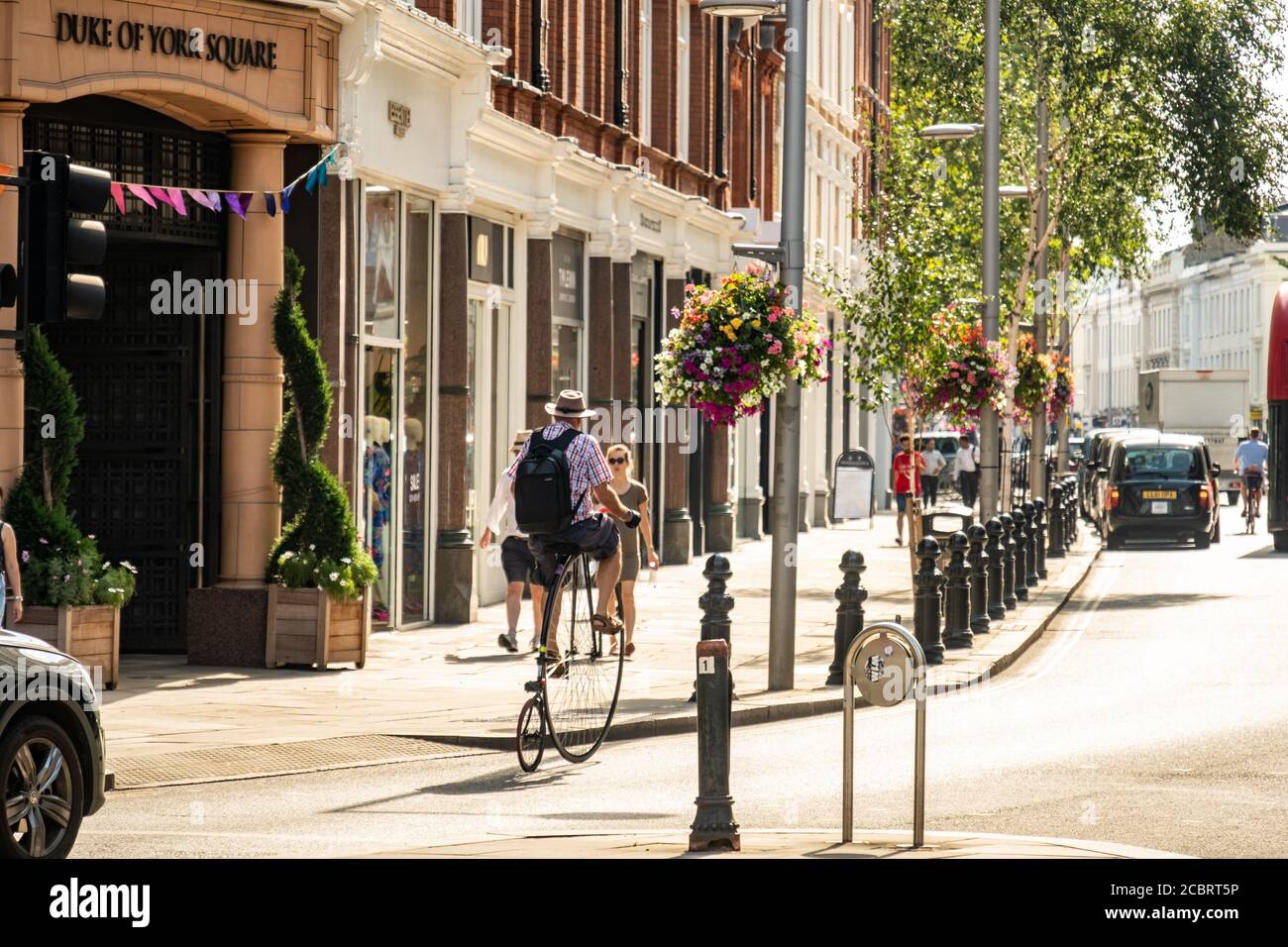 Un hombre en una bicicleta de Penny Farthing en Kings Road, Chelsea Foto de stock