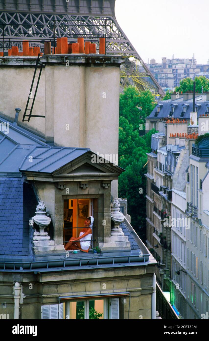Mujer en el apartamento de París cerca de la Torre Eiffel bebiendo té con un cabello en la toalla después de la ducha Foto de stock