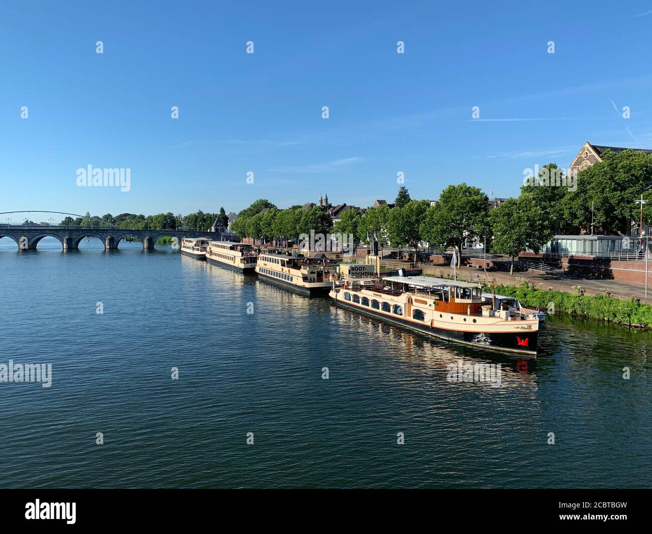 Ciudad con barcos en el río Mosa (Maas) y la iglesia de Augustijnen en Maastricht, Holanda. Foto de stock