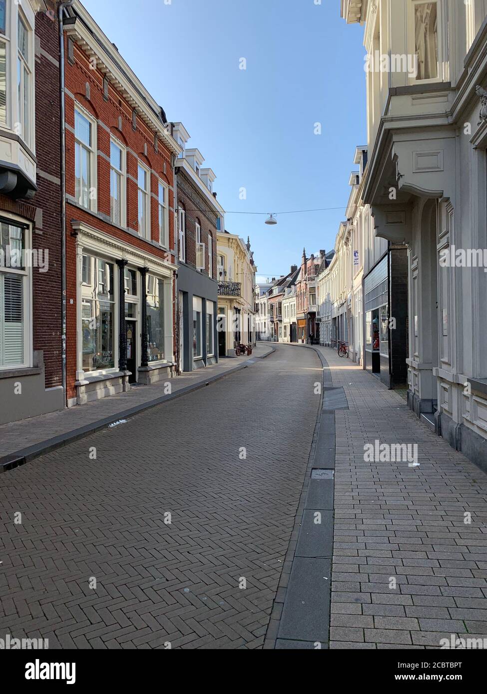 Calle Nieuwlandstraat vacía en la ciudad de Tilburg, países Bajos. Foto de stock