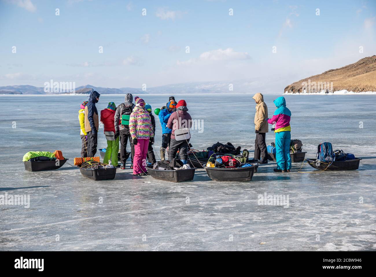 Un grupo de turistas con trineos de hielo en la superficie congelada del lago Baikal, Rusia Foto de stock