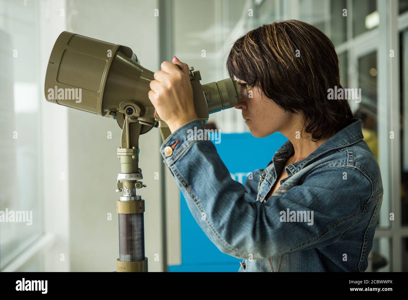 Mira al futuro. Retrato de una mujer segura de mediana edad mirando a través de binoculares Foto de stock