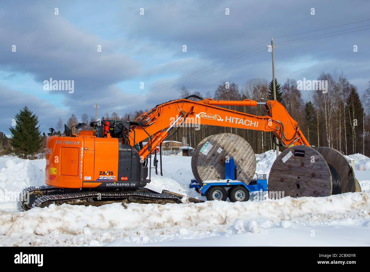 Naranja Hitachi Zaxis 225 US LC digger y rollos de cable en el sitio de excavación de nieve en invierno, Finlandia Foto de stock
