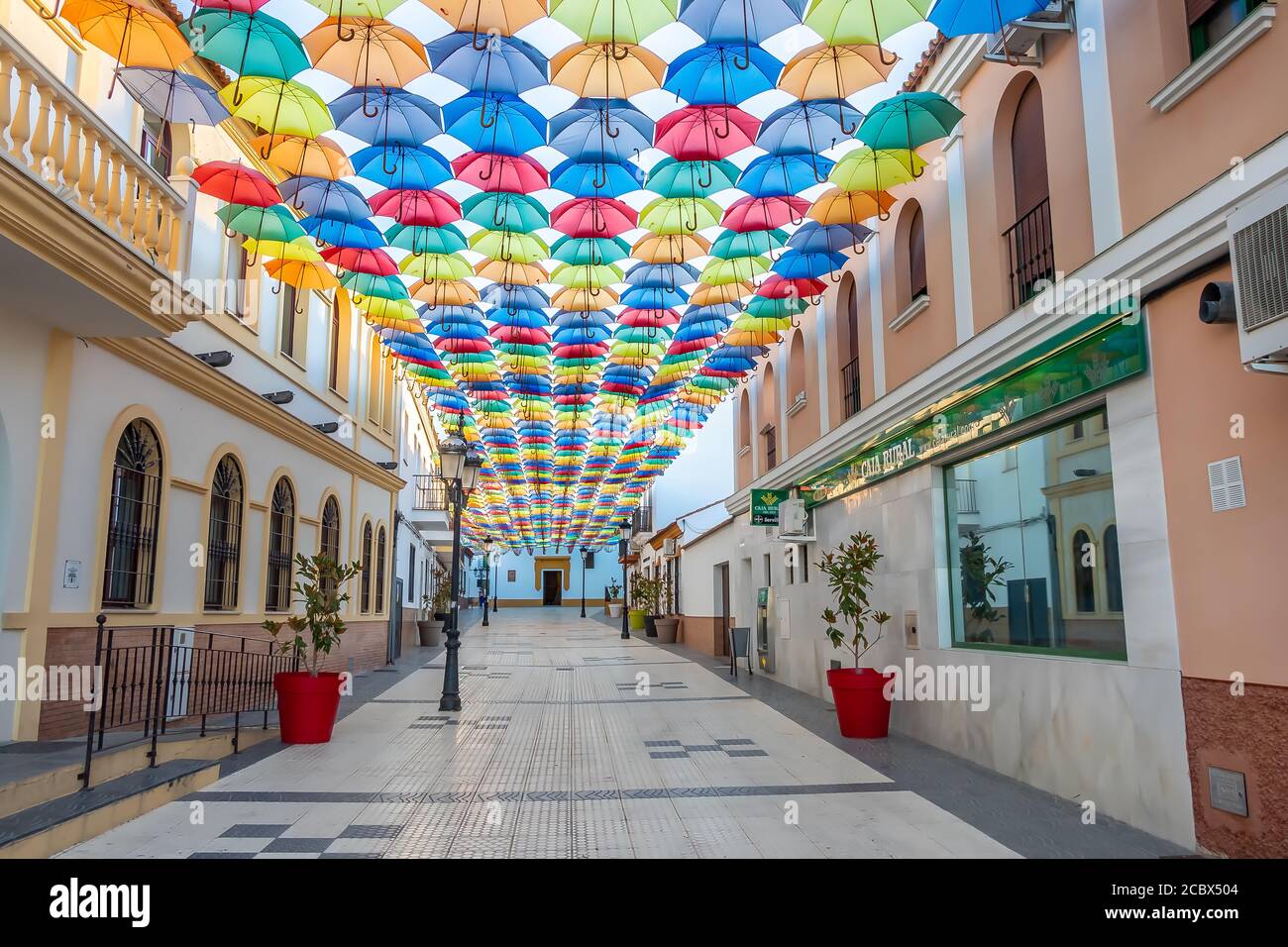 Huelva, España - 15 de agosto de 2020; el cielo está lleno de coloridos  paraguas. Calle con sombrillas en el cielo en el pueblo de San Bartolomé de  la torre. Suma Fotografía