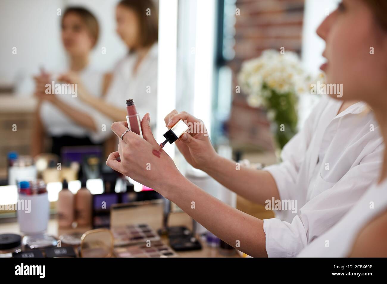 foto de primer plano de la mano de un artista profesional de la imagen de lápiz labial estudiantes en clase magistral Foto de stock