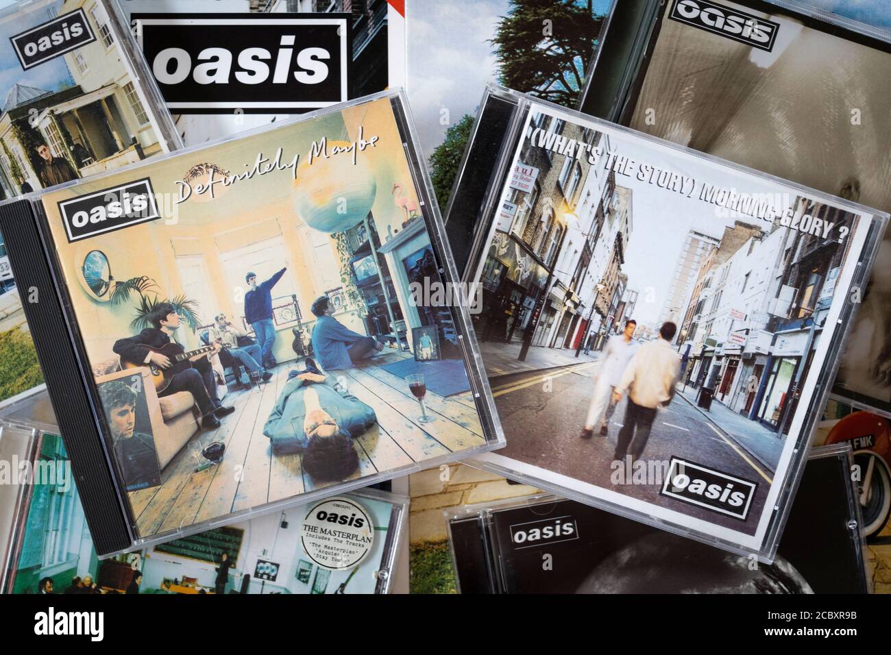 Una selección de álbumes de Oasis CD con portadas incluyendo su Álbum debut definitivo Maybe y segundo álbum What's The Story Gloria de la mañana - Britpop Foto de stock