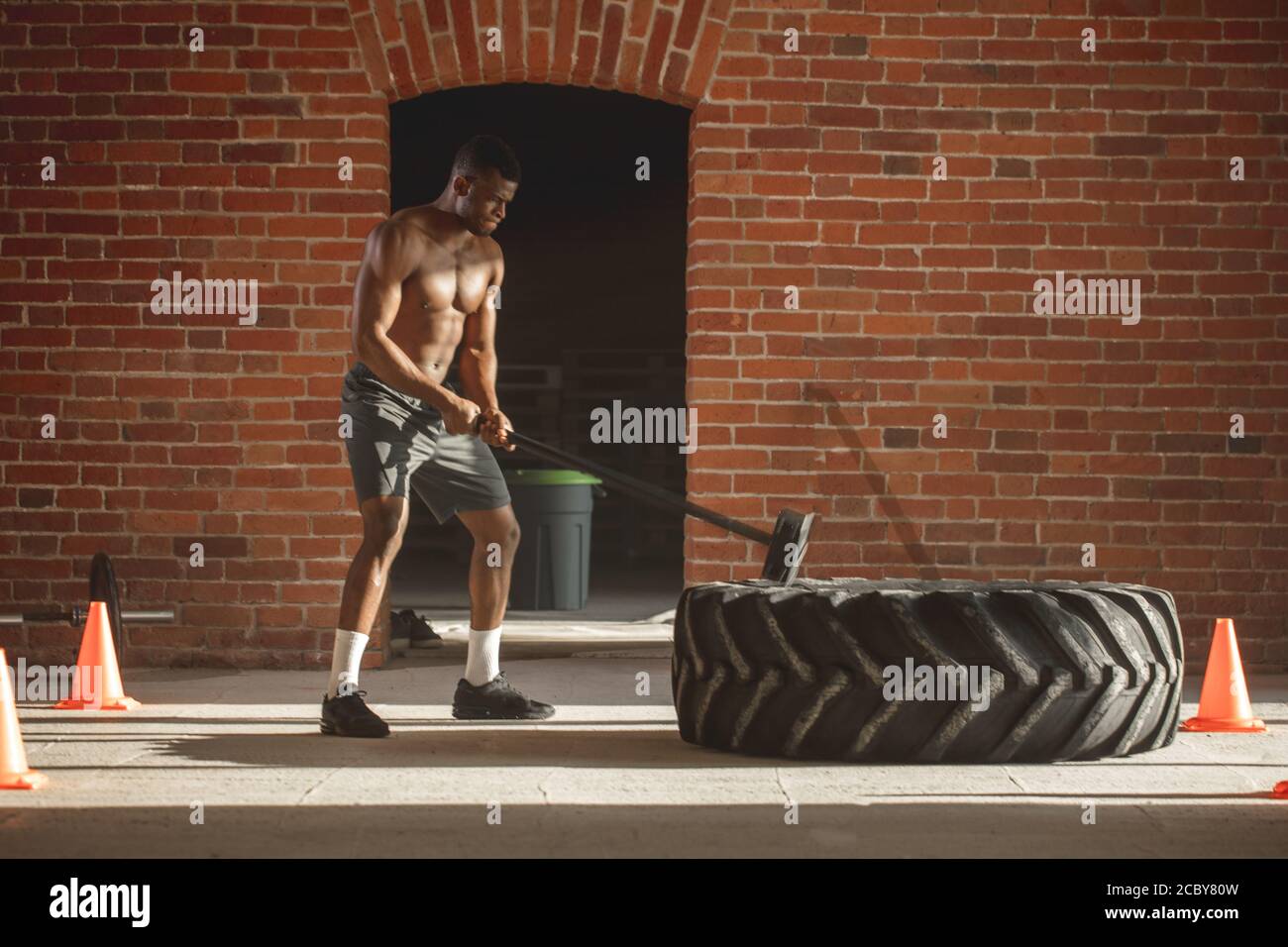 Fitness Deporte hombre golpeando con un martillo neumático de rueda de  patín entrenamiento Crossfit, joven chico saludable gimnasio interior  Fotografía de stock - Alamy