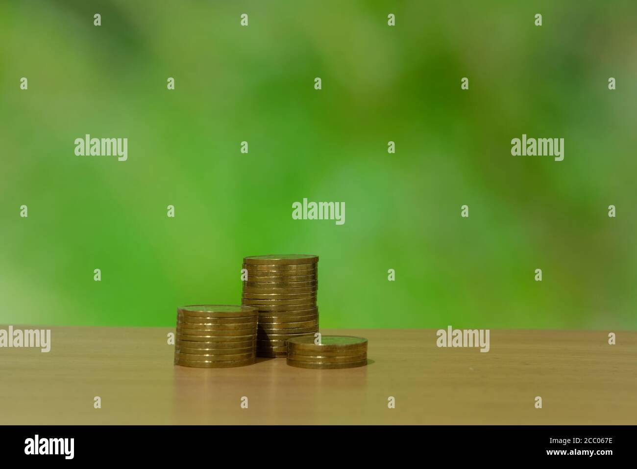 Pila de moneda de oro sobre una mesa de madera Foto de stock