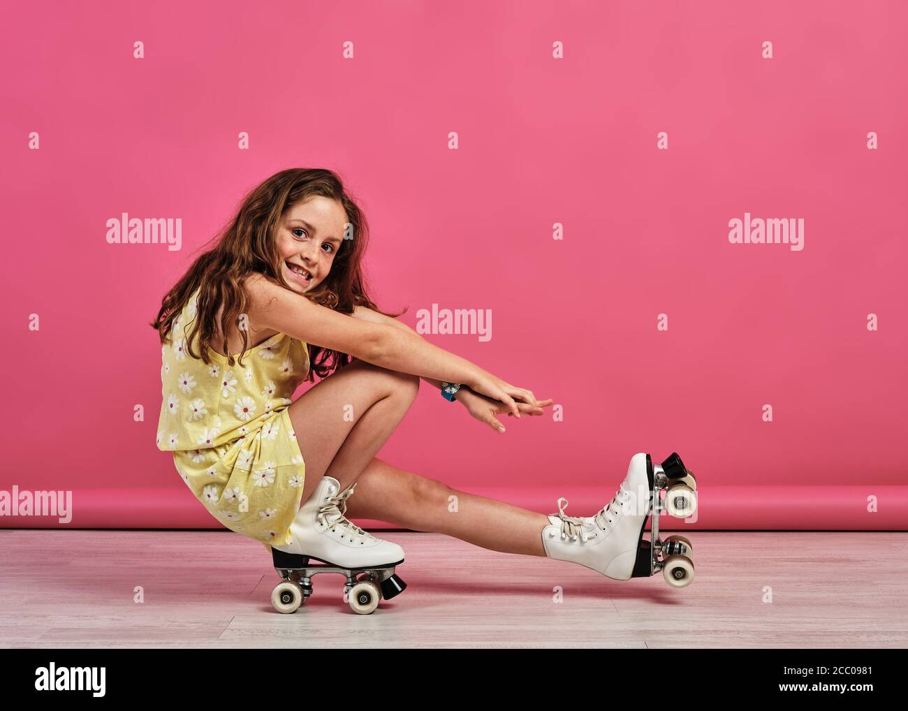 Niña haciendo trucos con patines en un estudio con un fondo rosa Fotografía  de stock - Alamy