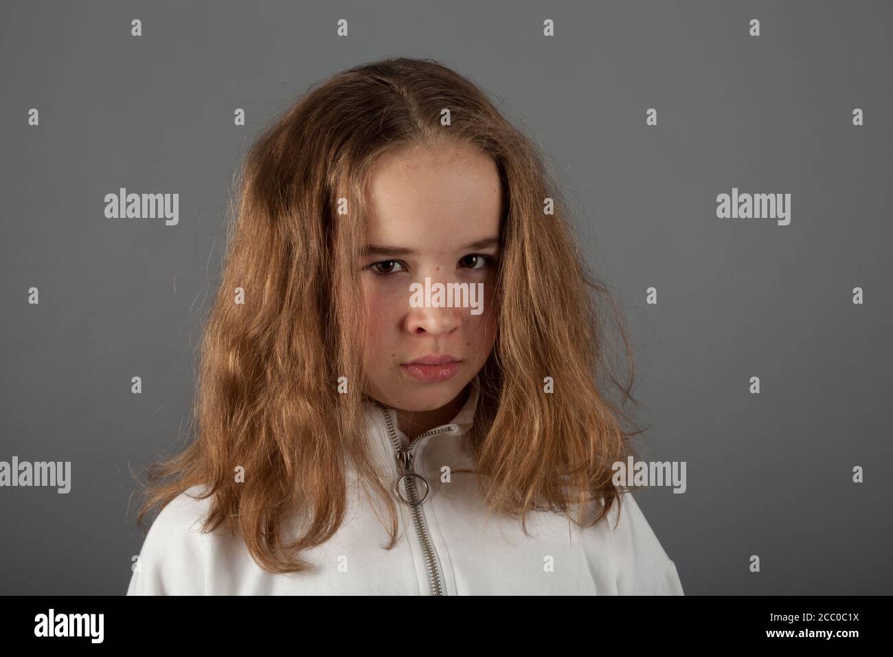 Linda adolescente rubia chica con capucha blanca con cara triste expresión Foto de stock