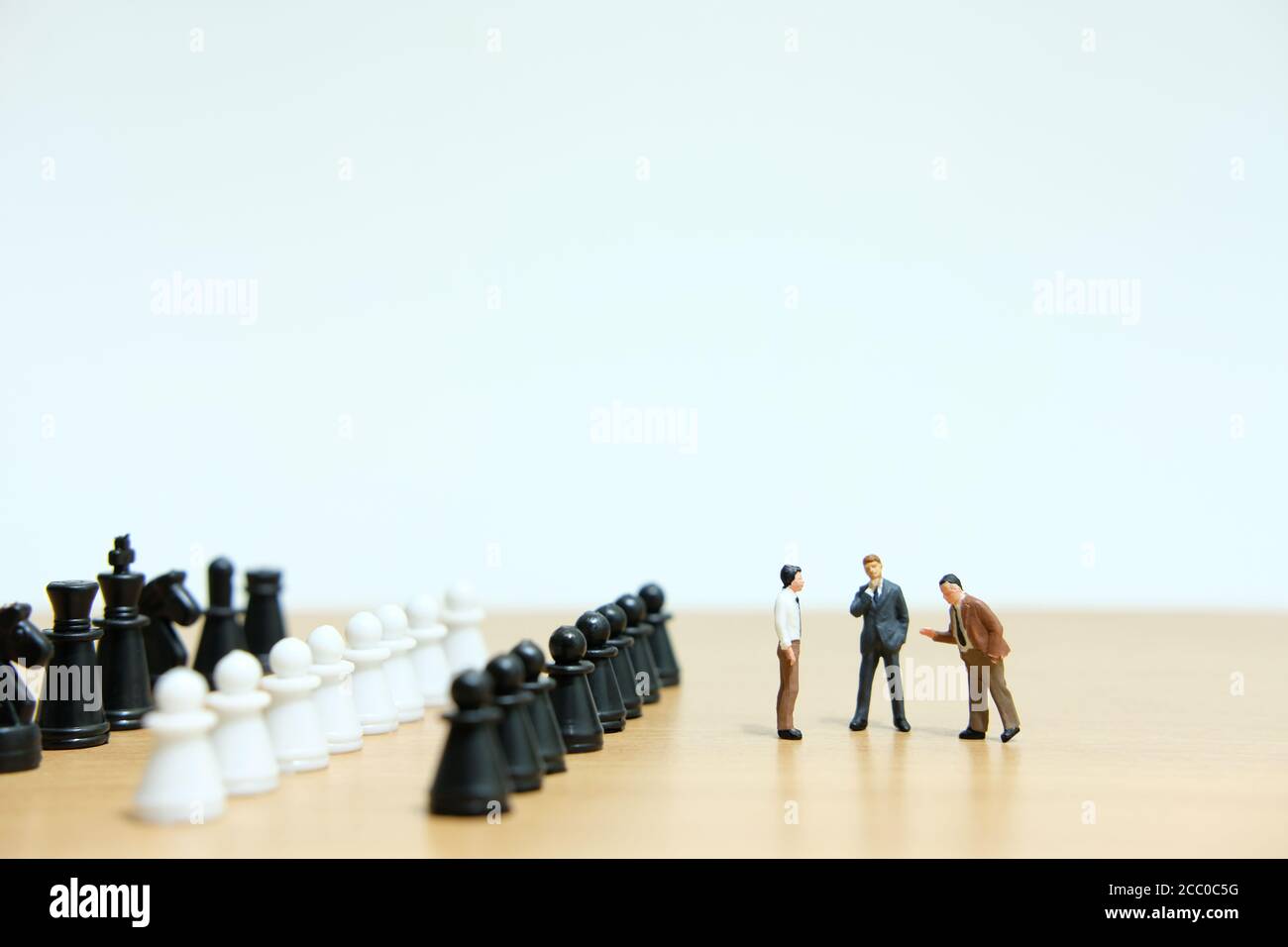 Miniatural concepto estratégico de personas - grupo de discusión de hombres de negocios tablero de ajedrez Foto de stock