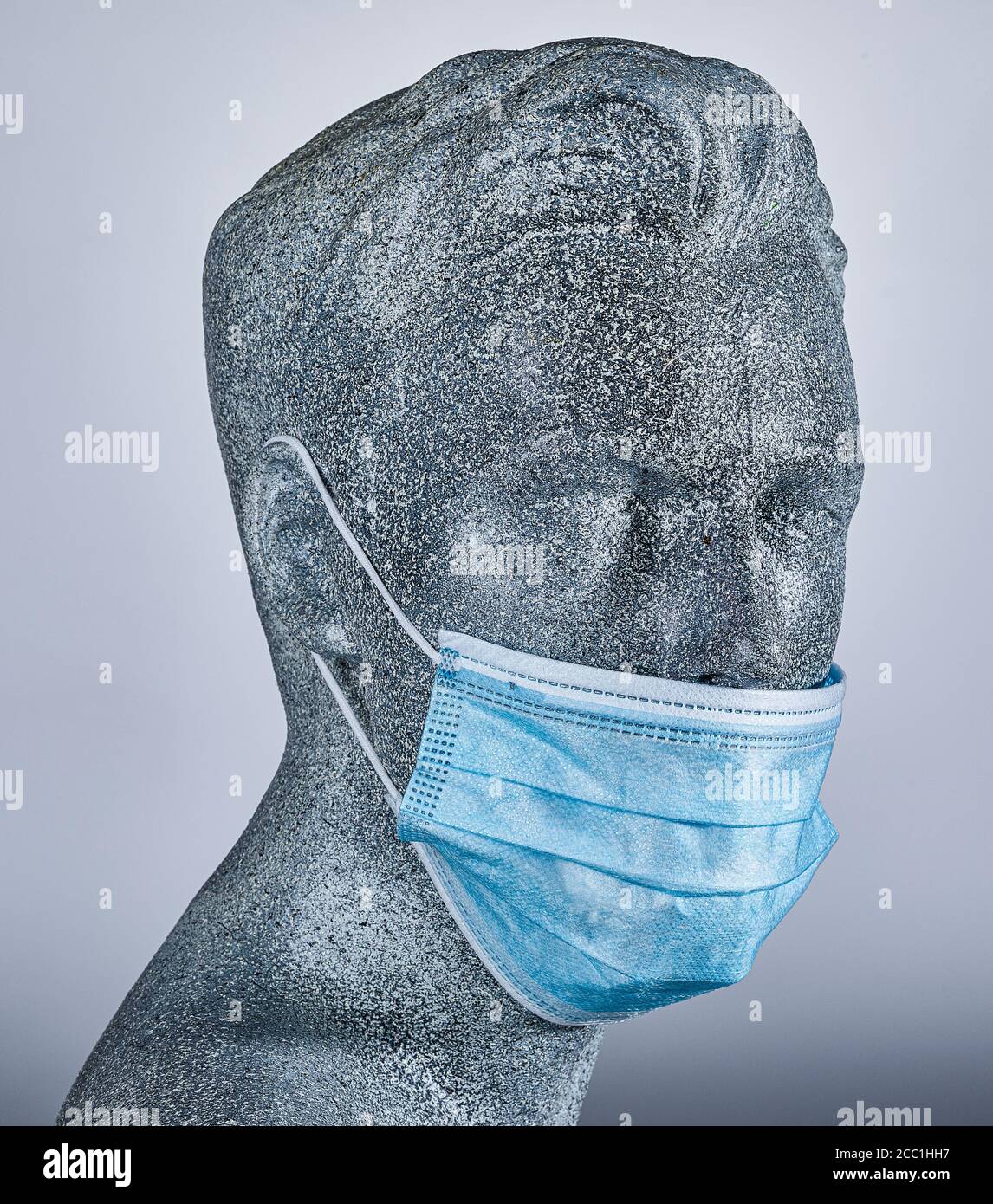 Pantalla masculina ficticia, con una máscara médica protectora, sobre fondo gris Foto de stock