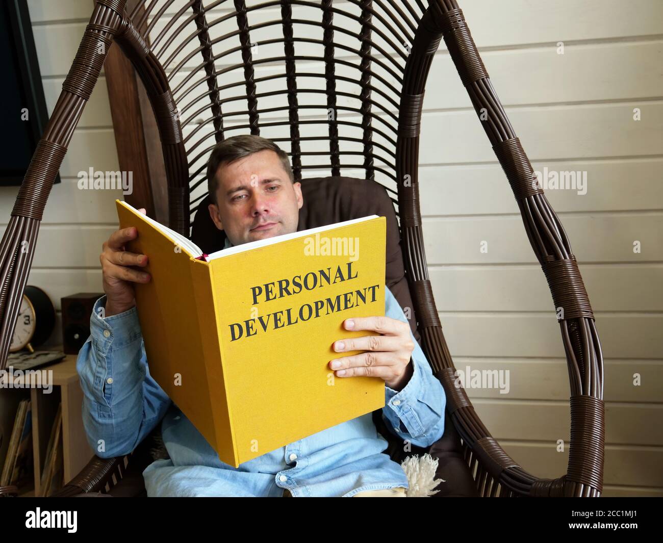 El tipo en casa lee el plan de desarrollo personal. Foto de stock