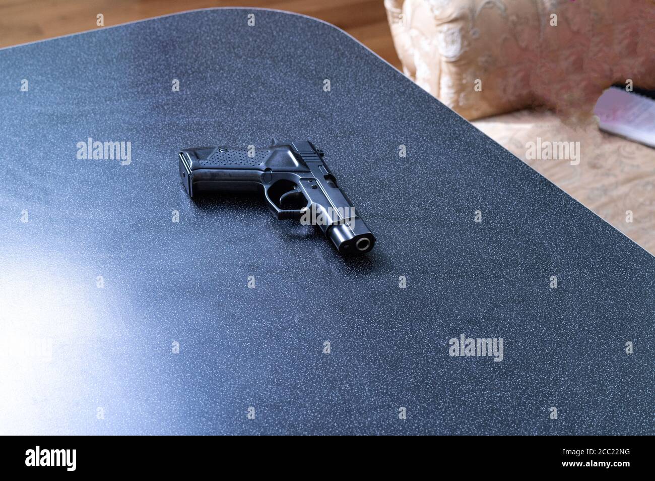 Arma de fuego en el escritorio de la casa. Pistola negra. Vista superior  Fotografía de stock - Alamy