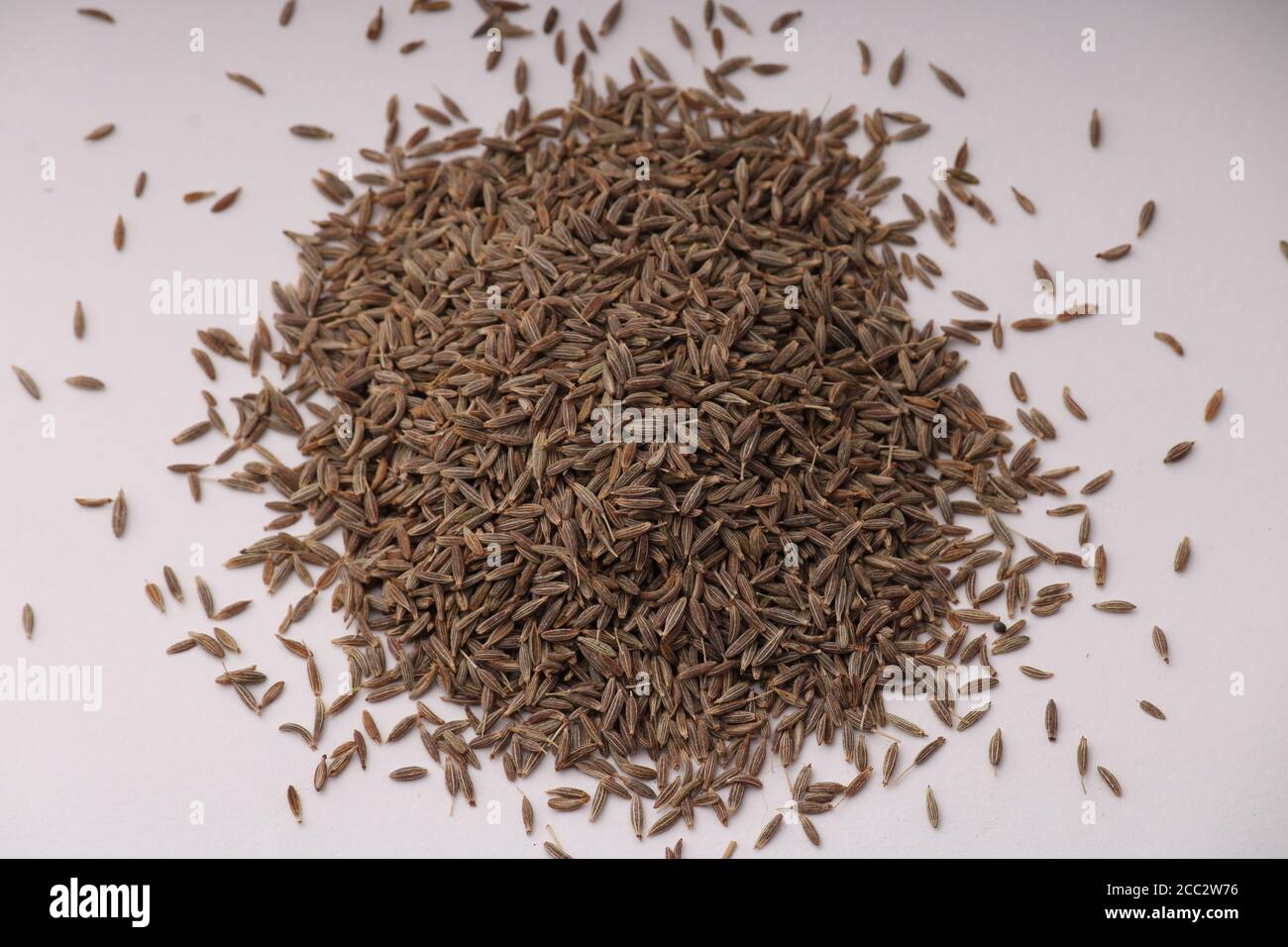 Montón de semillas de comino aislado sobre fondo blanco. Foto de stock
