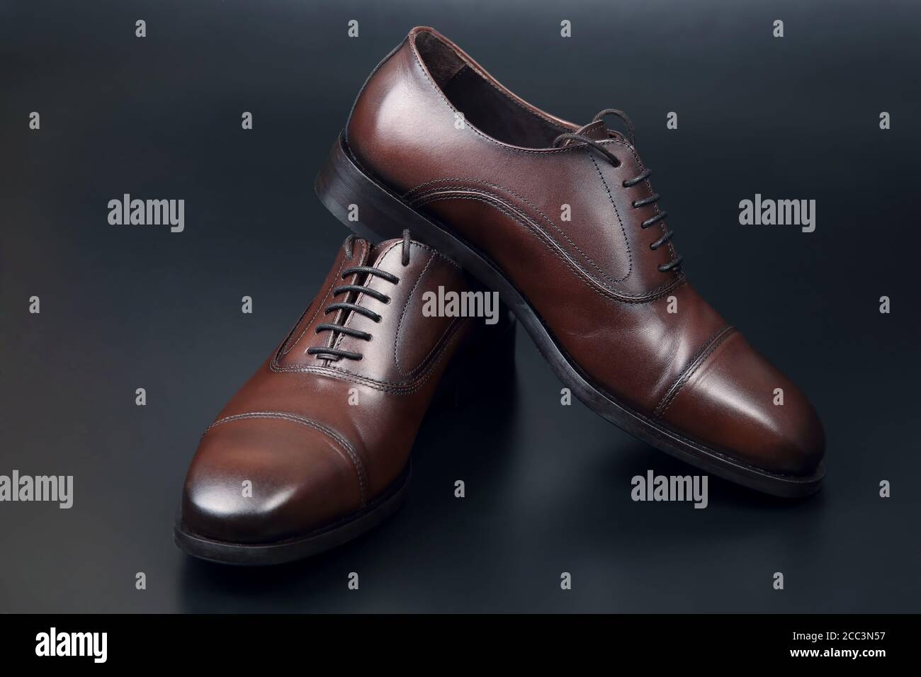 Zapatos Oxford clásicos marrones hombre sobre fondo oscuro Fotografía de stock - Alamy