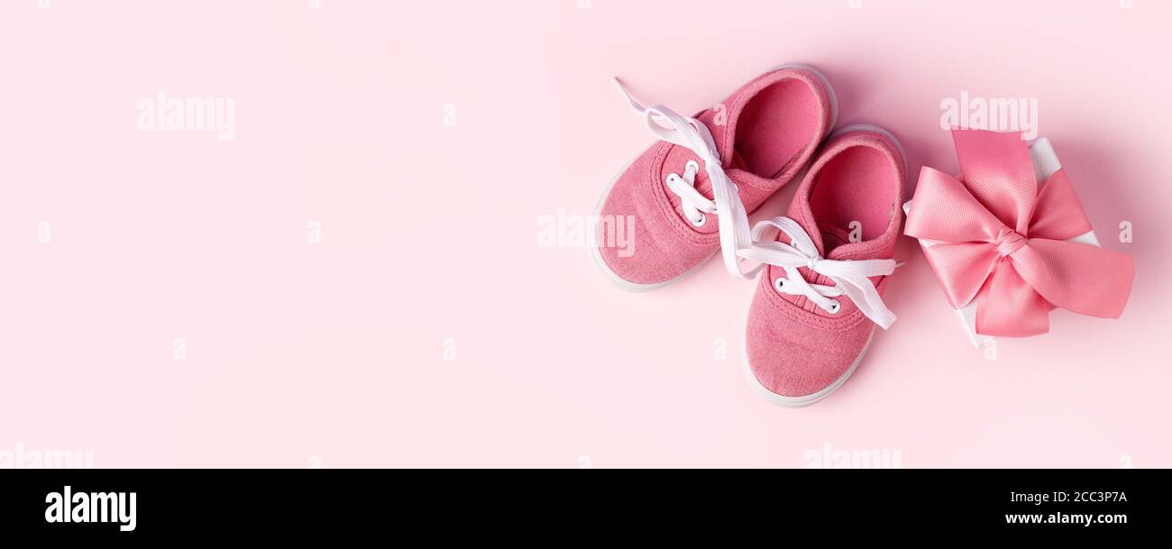 Zapatos rosa para bebés y caja de regalo, concepto de primeros pasos, cumpleaños, expectativa, embarazo, maternidad, maternidad, paternidad. Tarjeta monocroma para Foto de stock