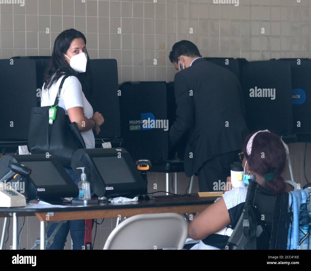 Miami, Estados Unidos. 18 de agosto de 2020. Los residentes de Miami Florida se matriculan en el mostrador de inscripción y depositan su papeleta el día de las elecciones primarias para los candidatos en la Estación de Bomberos y Rescate de Miami 2 en Miami, Florida el martes, 18 de agosto de 2020. Las líneas en los sitios de votación son más cortas y en algunos casos inexistentes debido al COVID-19, Coronavirus Pandémica. Foto de Gary I Rothstein/UPI crédito: UPI/Alamy Live News Foto de stock