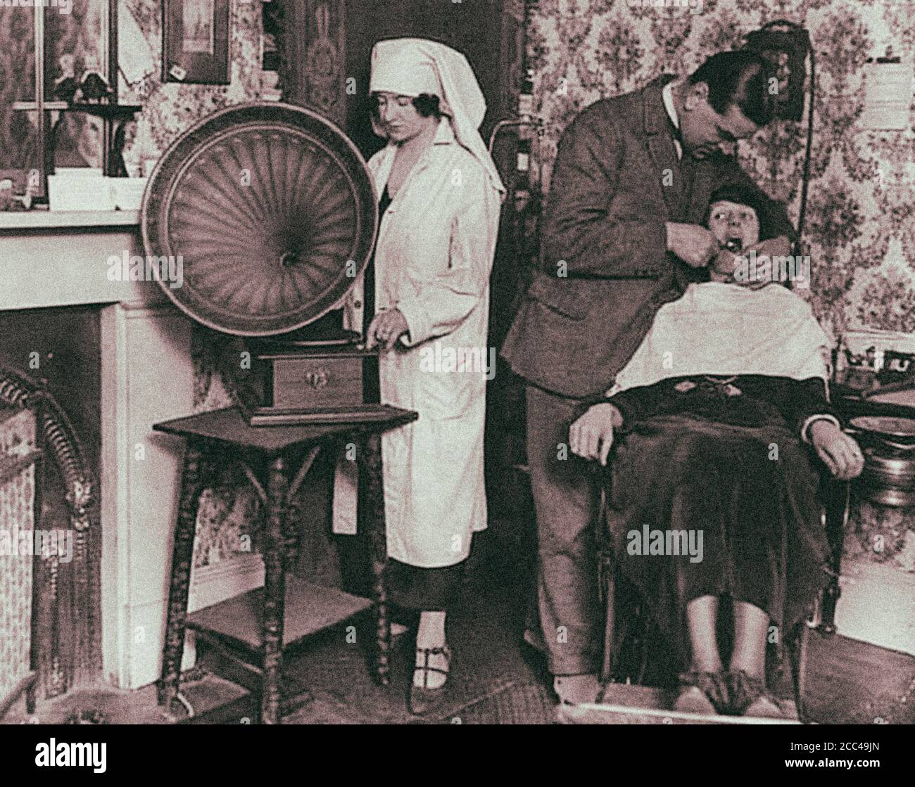 Tecnologías al servicio de los dentistas. La música alta debe distraer el dolor durante el tratamiento. 1920 Foto de stock