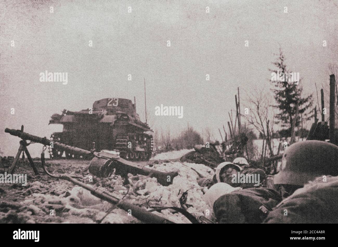 Soldados alemanes de infantería de la Wehrmacht nazi se esconden en una zanja al borde de la carretera durante la invasión de Noruega en abril de 1940. En el camino está Panze Foto de stock