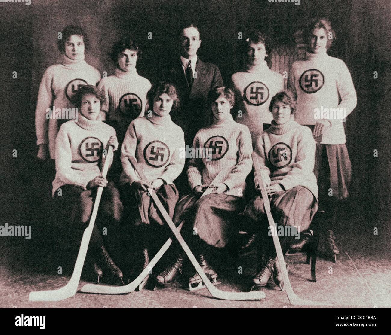 Foto retro de un equipo canadiense de hockey sobre hielo femenino de Edmonton con un cartel de swastika en sus suéteres. 1916 Foto de stock