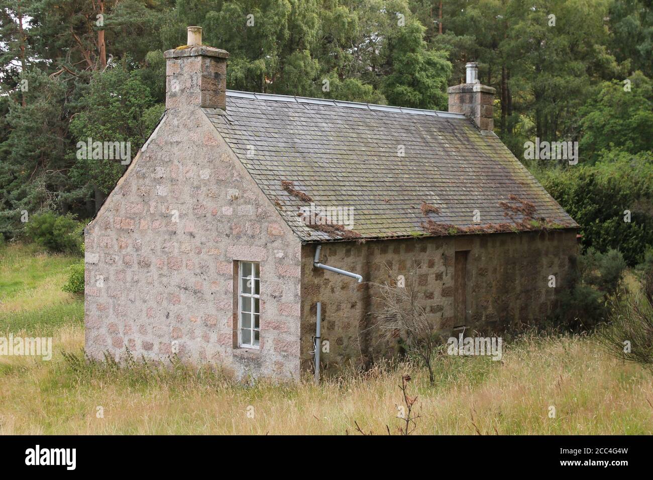 Casa de campo construida en piedra con techo de pizarra en el bosque  Fotografía de stock - Alamy