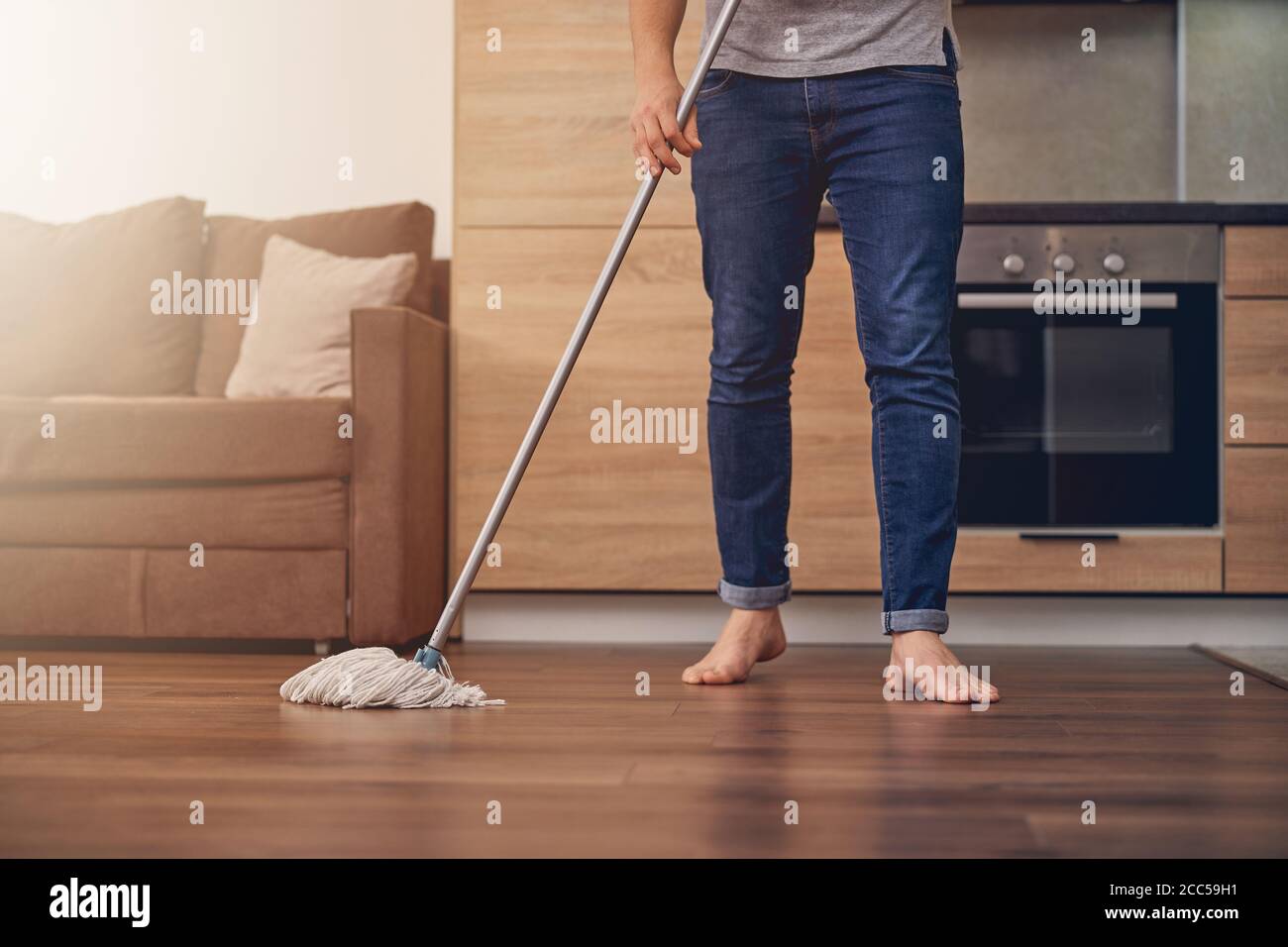 Guapo Limpiador Masculino En Sofá Gris De Limpieza Uniforme Con Aspiradora  Moderna. Chico Indio Con Guantes De Goma Quitando La Suciedad Del Sofá En  Un Apartamento Moderno Fotos, retratos, imágenes y fotografía