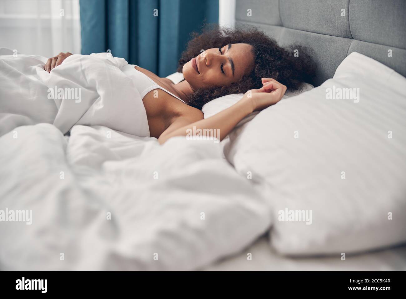 Hermosa mujer de pelo oscuro explanando sobre la almohada Foto de stock