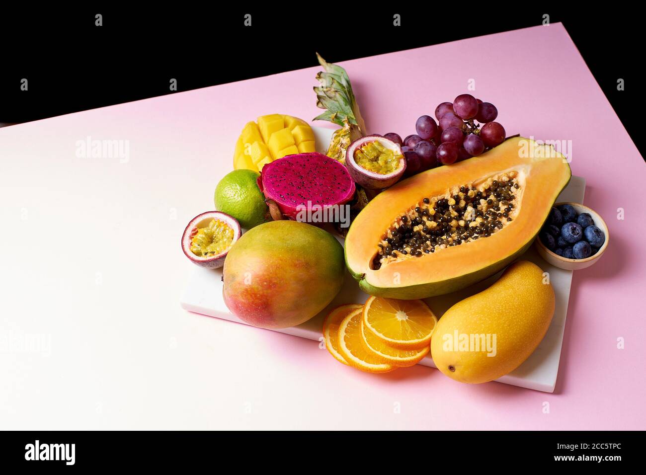 Las frutas tropicales siguen siendo de mango, papaya, pitahaya, fruta de la pasión, uvas, lima y piña. Plato de fruta Foto de stock