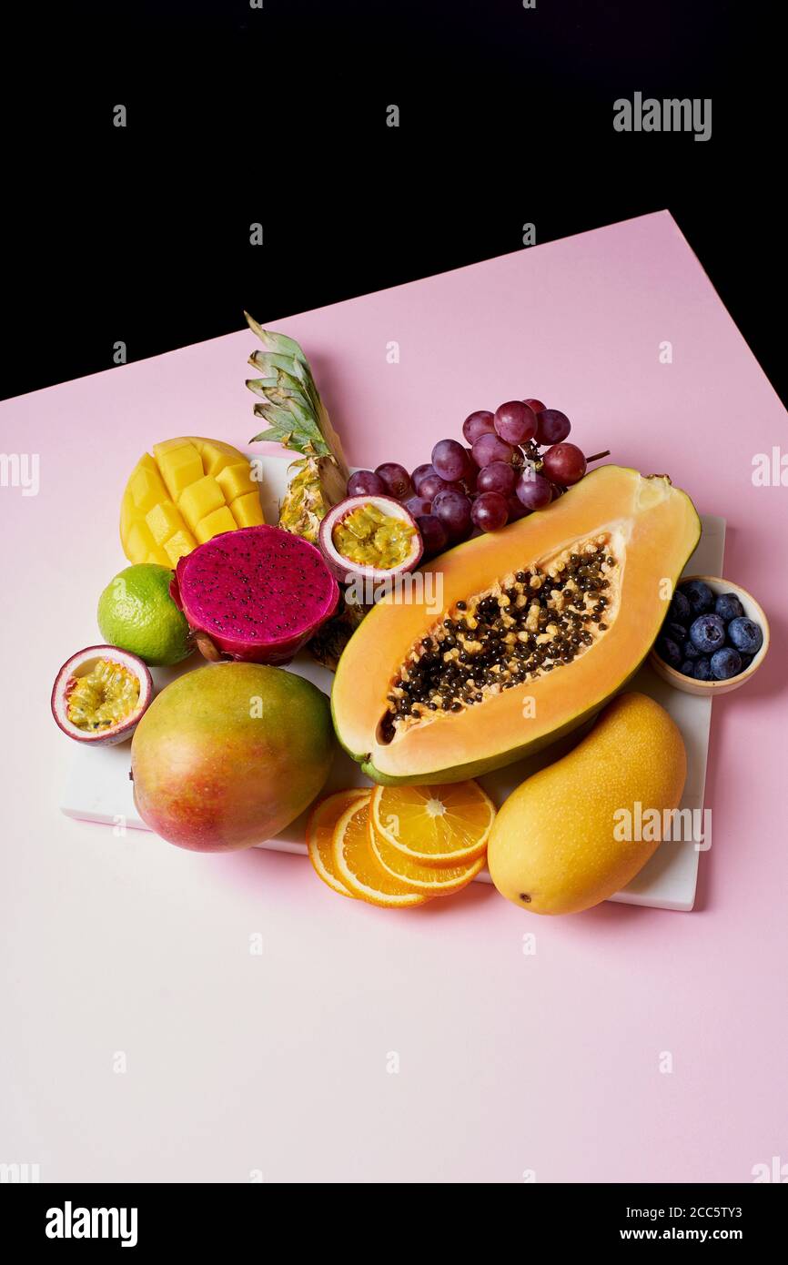 Las frutas tropicales siguen siendo de mango, papaya, pitahaya, fruta de la pasión, uvas, lima y piña. Plato de fruta Foto de stock