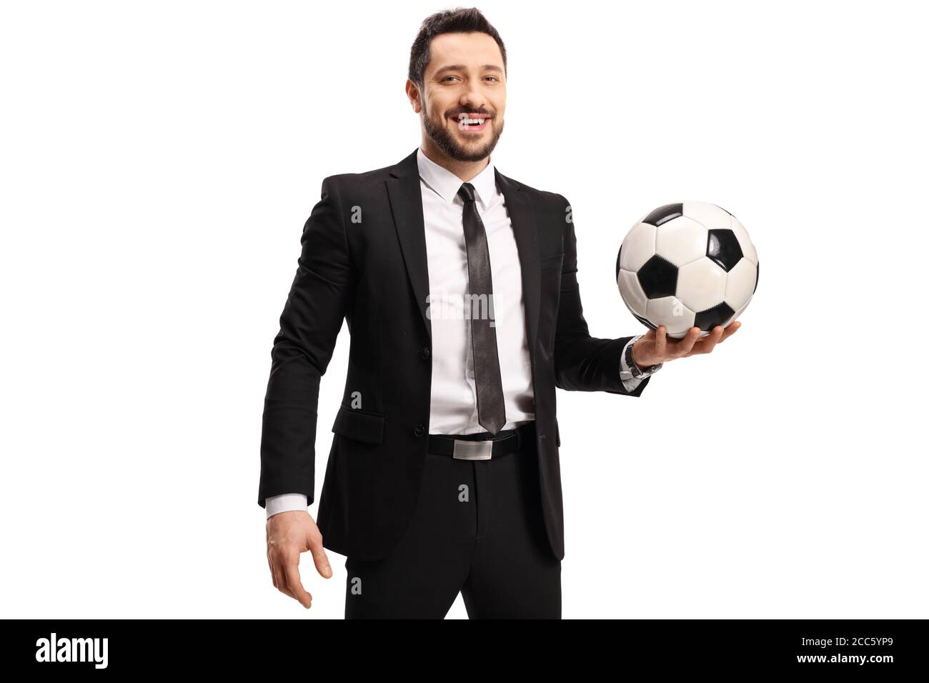 Hombre profesional en traje negro con un balón de fútbol aislado sobre fondo blanco Foto de stock