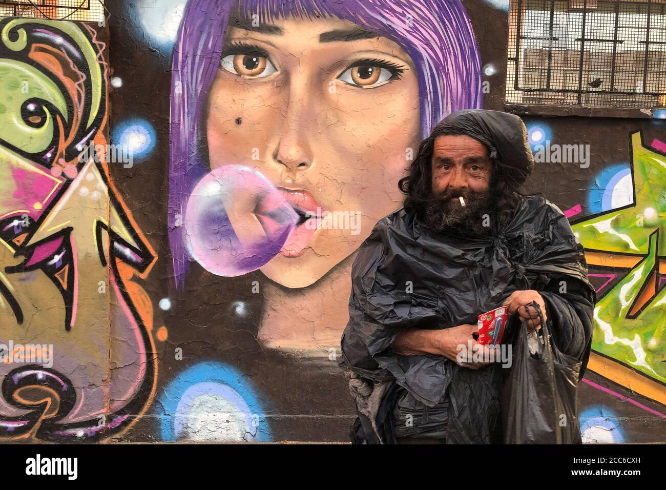 Diego, un hombre sin hogar vestido con bolsas de basura, se prepara para  beber leche durante el brote de la enfermedad del coronavirus (COVID-19) en  Santiago, Chile 13 de agosto de 2020.