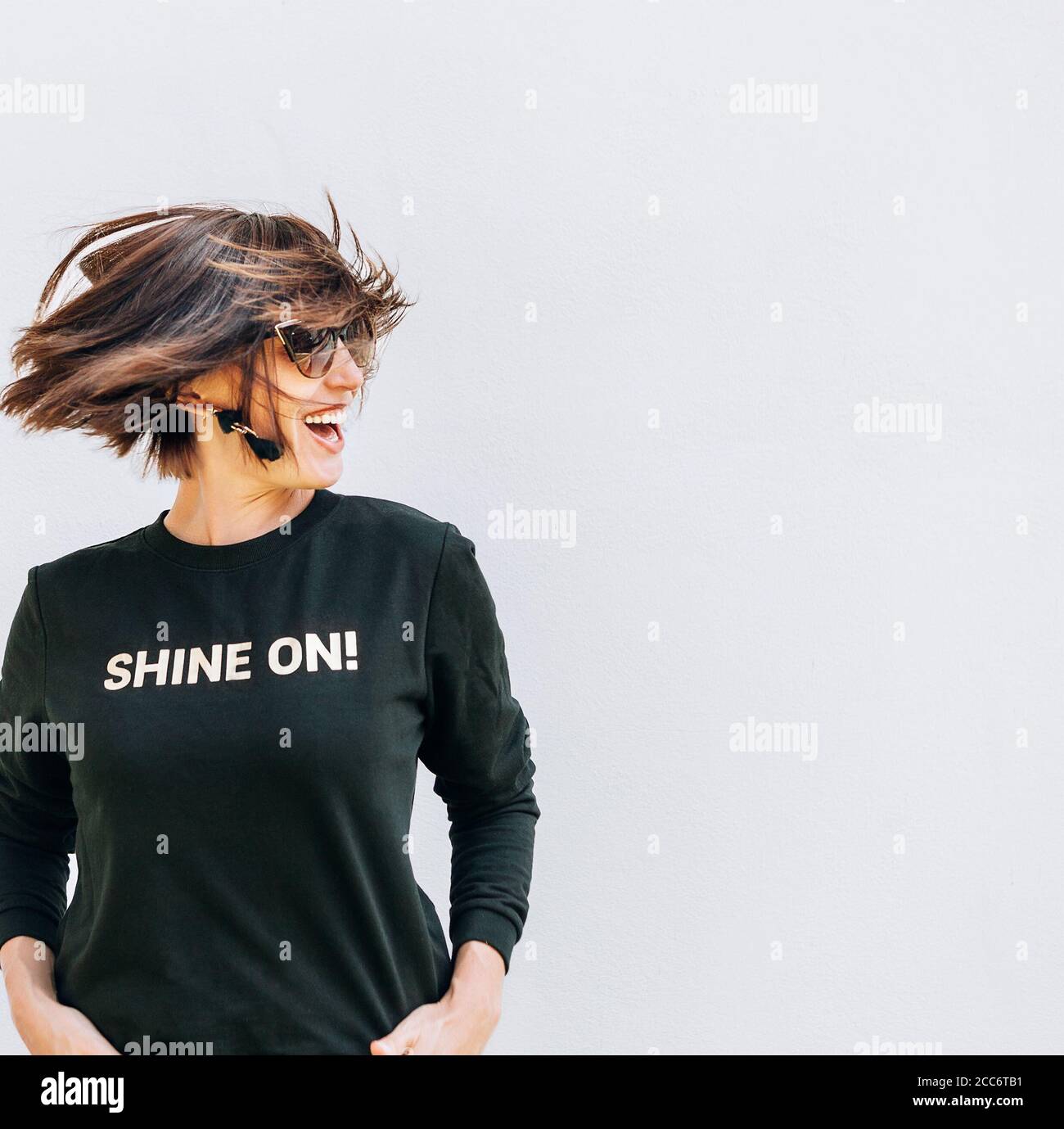 Riendo Mujer feliz posando en sudadera negra con estampado de niñera Brilla  Fotografía de stock - Alamy