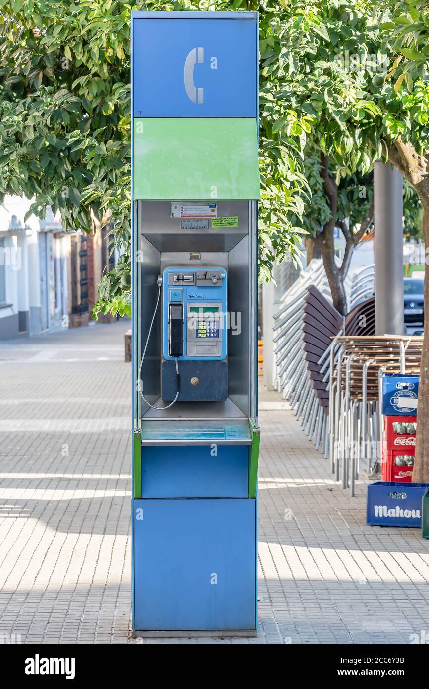Huelva, España - 16 de agosto de 2020: Cabina telefónica de la empresa telefónica en el centro de la ciudad de Valverde del camino. Uno de los viejos e inútiles teléfonos públicos t Foto de stock