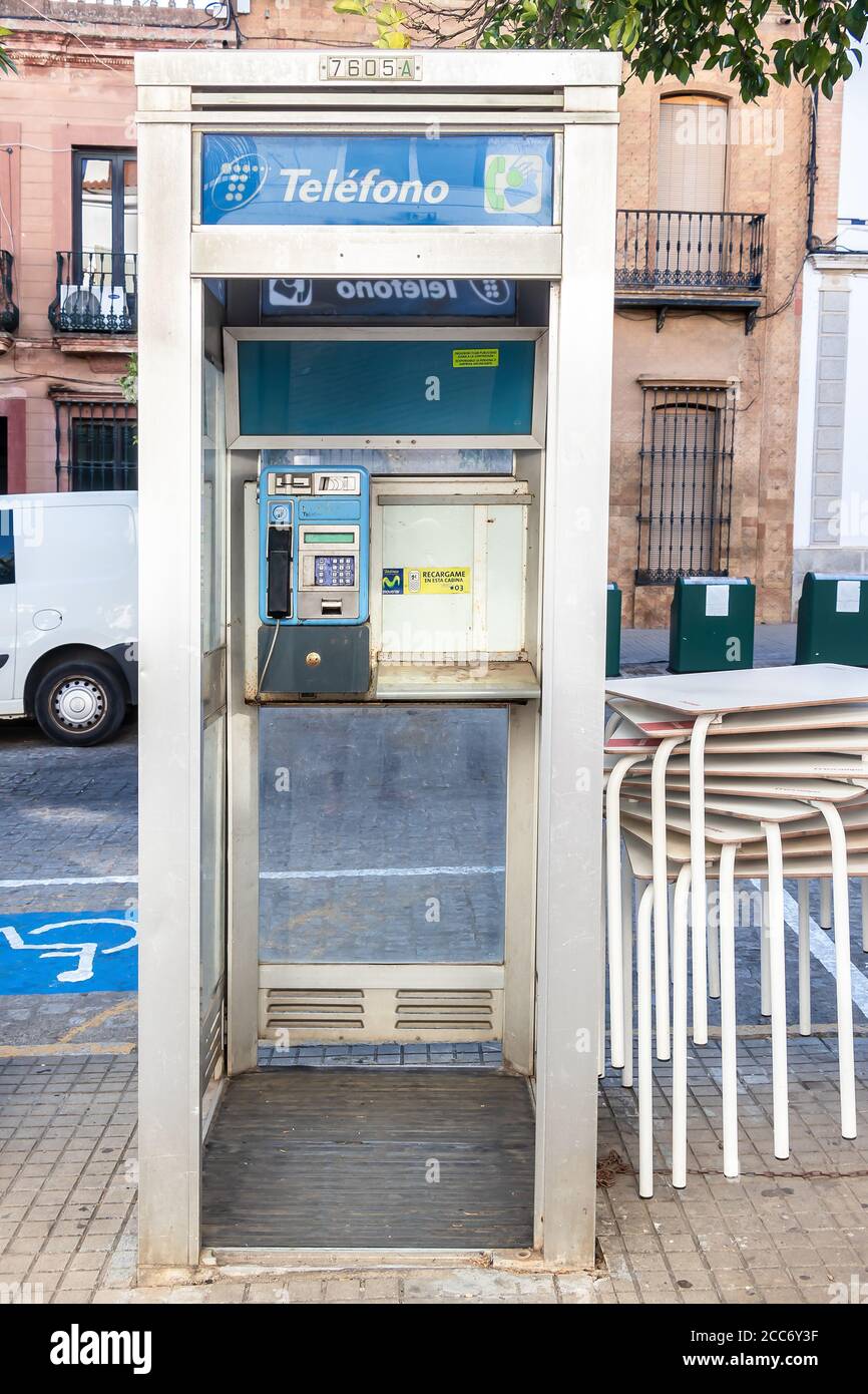 Huelva, España - 16 de agosto de 2020: Cabina telefónica de la empresa telefónica en el centro de la ciudad de Valverde del camino. Uno de los viejos e inútiles teléfonos públicos t Foto de stock