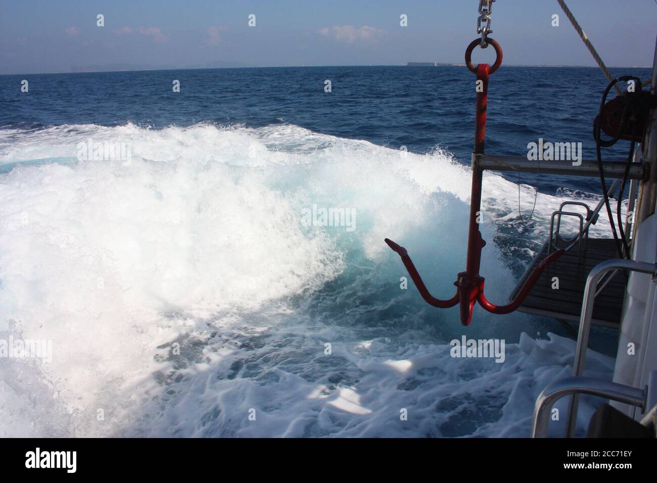 ancla de mar rojo de un barco en el mar arriba la espuma blanca de las olas  y el agua azul del océano en las vacaciones de verano en la isla Fotografía