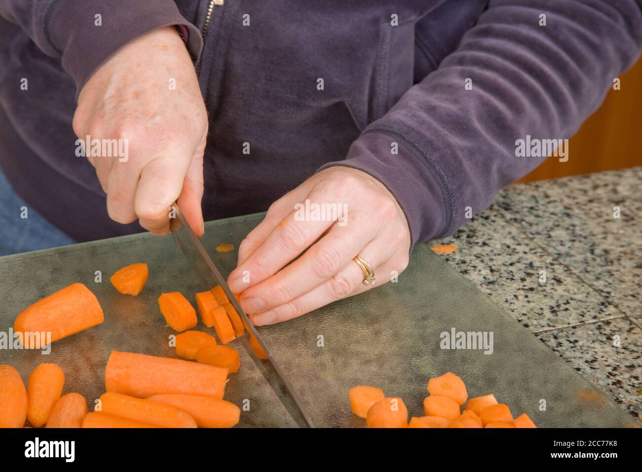 Mujer picando zanahorias con un cuchillo en preparación para blanquear y  congelar en la cocina Fotografía de stock - Alamy