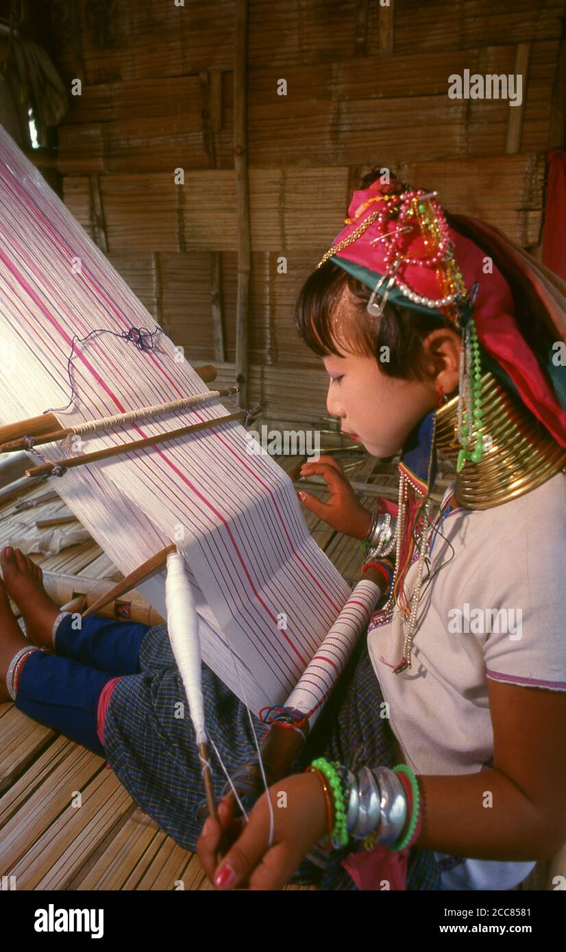 Tailandia: Padaung (cuello largo Karen) niña tejiendo, provincia de Chiang Mai, norte de Tailandia. Los Padaung o Kayan Lahwi o Karen de cuello largo son un subgrupo de los kayas, una mezcla de lawi, kayan y varias otras tribus. Kayan es un subgrupo de la población Karen Roja (Karenni), una minoría étnica Tibeto-Burman de Birmania (Myanmar). Foto de stock