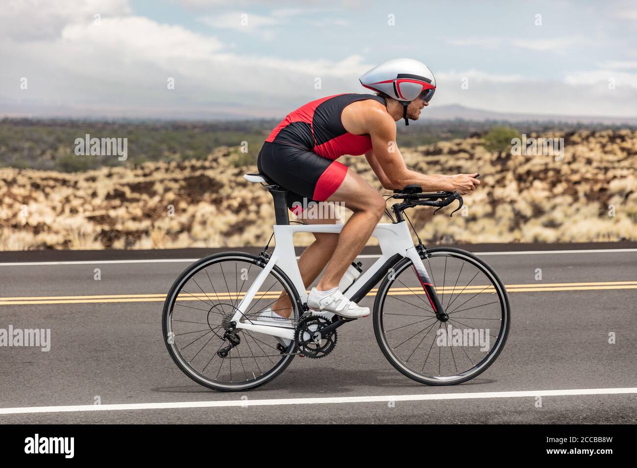 Bicicleta triatleta hombre ciclismo bicicleta carretera bajo la lluvia  durante la carrera de triatlón en el paisaje natural de Hawai. Deporte  atleta entrenamiento entrenamiento resistencia Fotografía de stock - Alamy