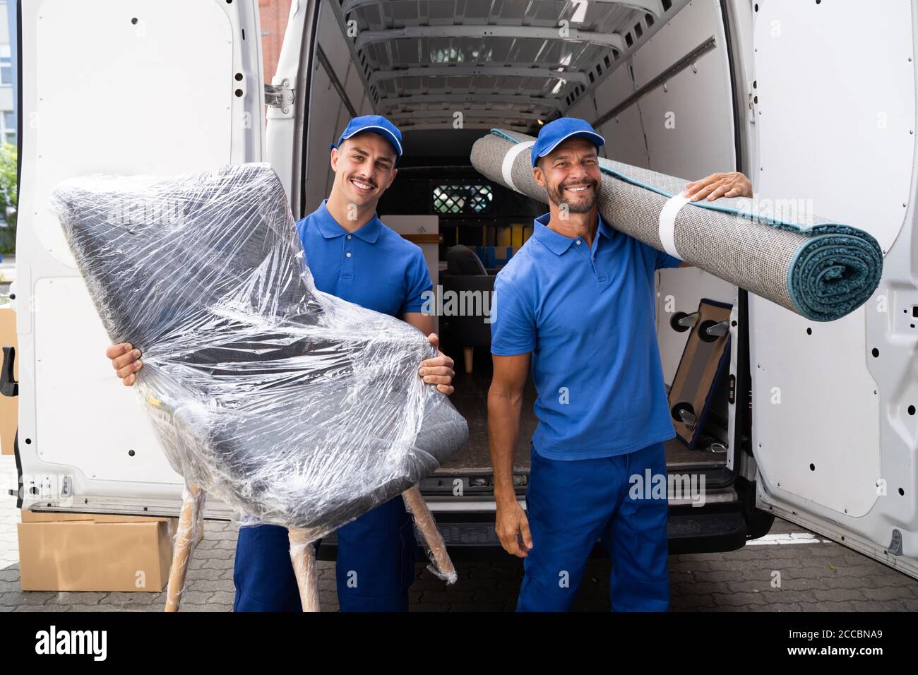 Movers haciendo el retiro del mobiliario y de la alfombra del carro o de la  furgoneta Fotografía de stock - Alamy