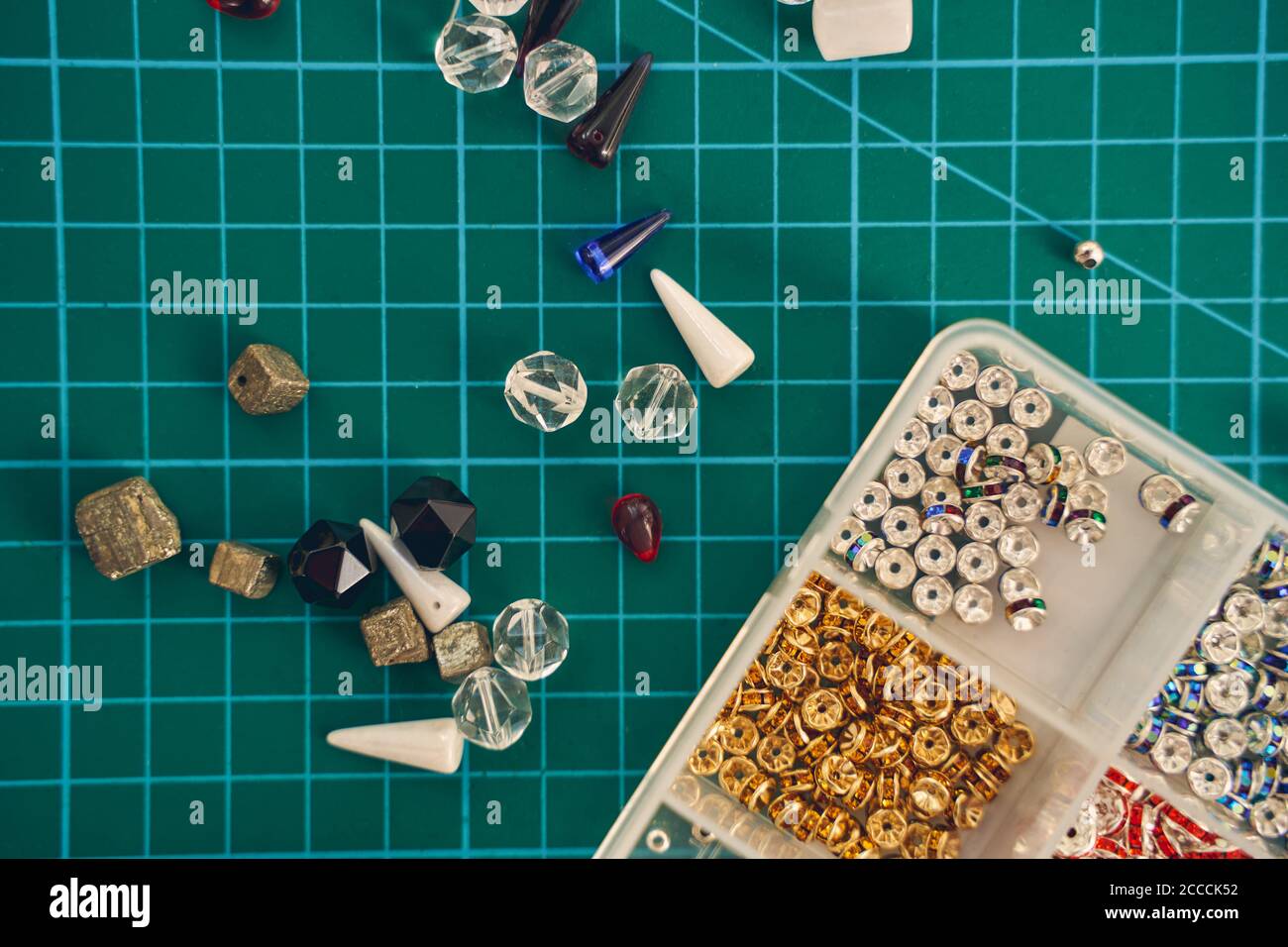 Cuentas de vidrio y semillas o de fieltro para la fabricación de joyas fondo verde Foto de stock