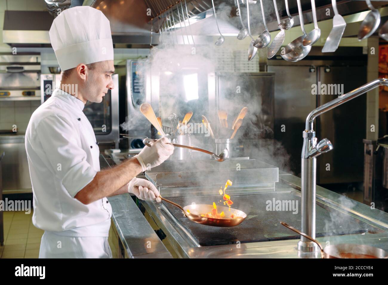 Chef de cocina verduras en wok pan. Dof superficial. Foto de stock