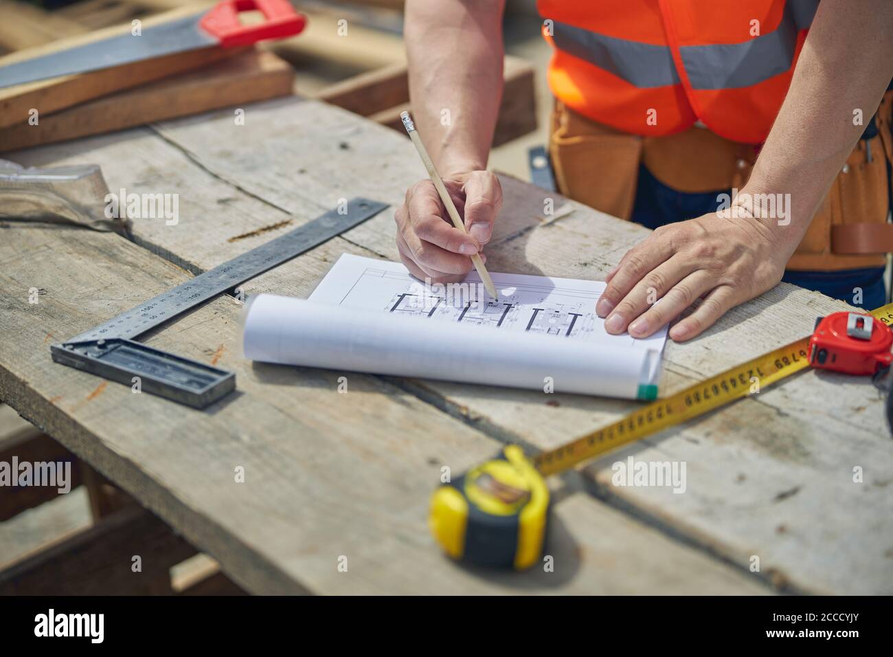 Trabajador masculino caucásico haciendo cambios en el plan de la casa Foto de stock