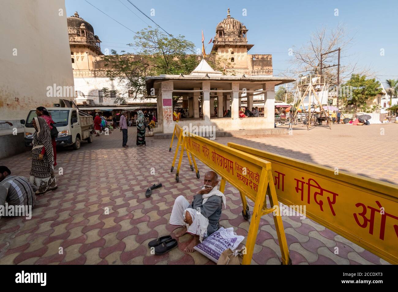 Orchha, Madhya Pradesh, India - Marzo de 2019: Un anciano peregrino indio masculino sentado en el piso pavimentado fuera del antiguo templo hindú Ram Raja en el Foto de stock
