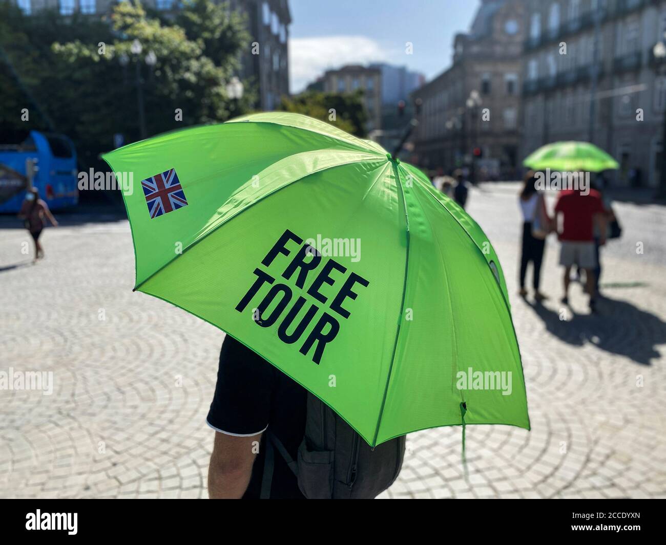 Un guía turístico tiene un paraguas con la imagen de la bandera británica  mientras espera a los turistas en la Avenida Aliados, después de que Gran  Bretaña retira a Portugal de su