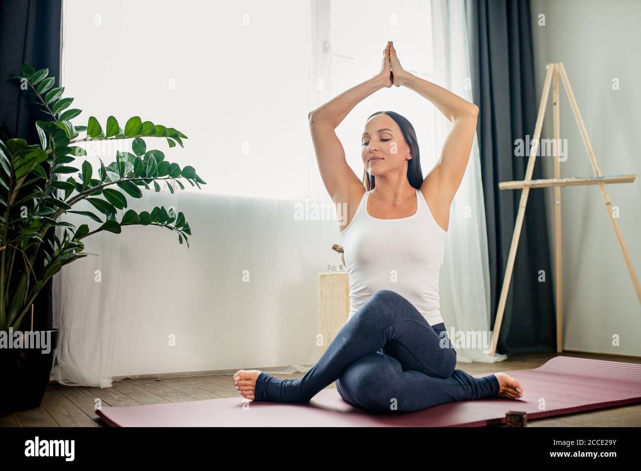 mujer caucásica flexible hacer ejercicios de yoga con piernas cruzadas en  el suelo, mujer saludable estirar cada mañana en casa Fotografía de stock -  Alamy