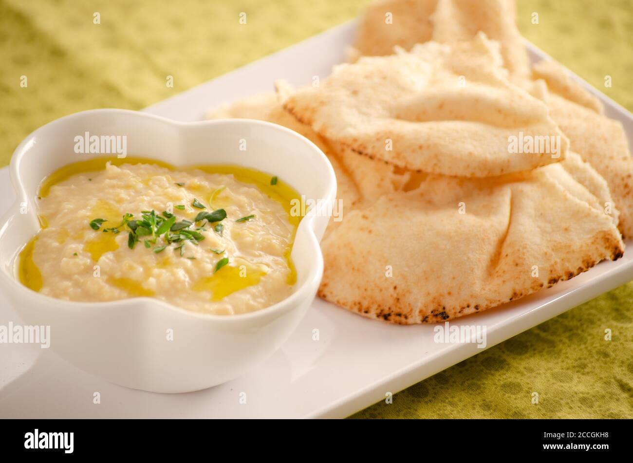 Un tazón de hummus fresco y pan de pita Foto de stock